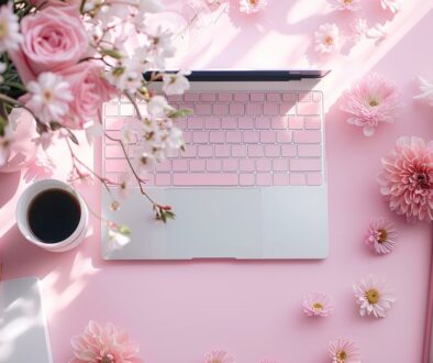 Flat lay laptop is on a table with a cup of coffee and a vase of flowers. Peaceful and relaxing, with the flowers